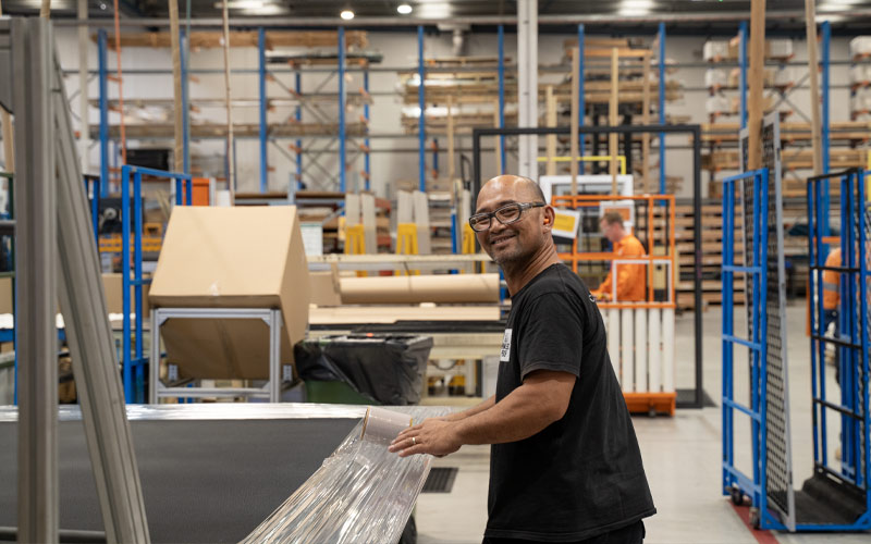 Factory worker wrapping security screens