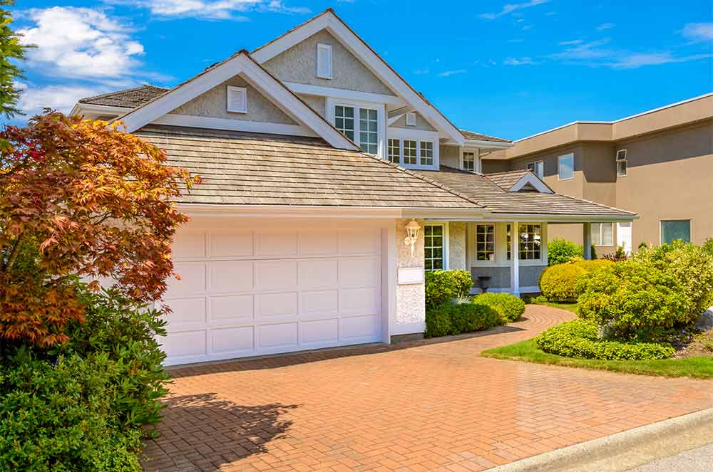 Front of a home with an empty driveway and the blinds open